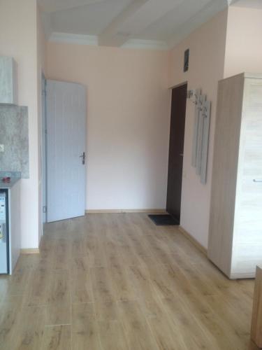an empty room with white walls and wooden floors at Nodari in Batumi