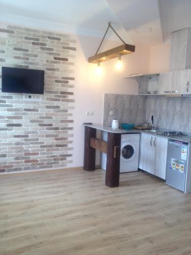 a kitchen with a counter and a washing machine at Nodari in Batumi