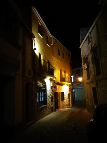 an empty alley at night with lights on a building at Hostal Hueso in Trujillo