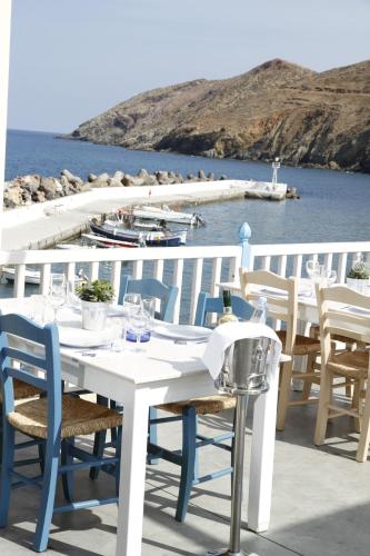 a white table and chairs with a view of the water at Captain's House Hotel Suites & Apartments in Panormos Rethymno