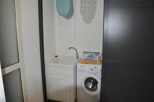 a bathroom with a washing machine and a sink at Costantino Home in Pompei
