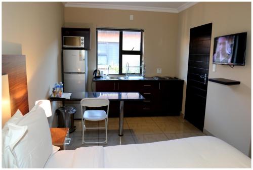 a kitchen with a sink and a table in a room at Eagle Nest Luxury Accommodation in Roodepoort