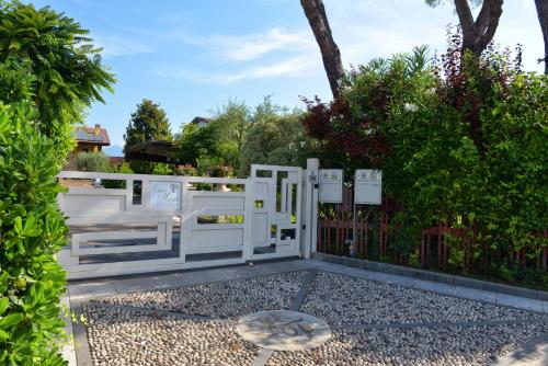 un portail blanc devant une clôture dans l'établissement Casa Maria, à Manerba del Garda