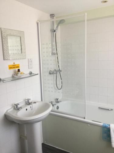 a bathroom with a sink and a tub and a shower at The Haymaker Inn in Chard