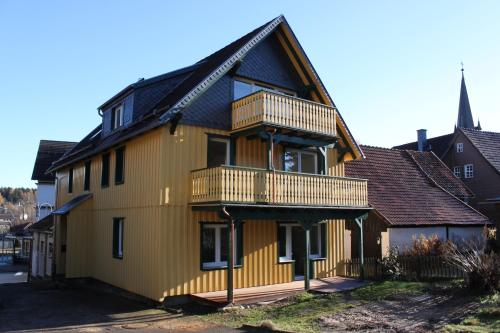 una casa amarilla con techo negro en Haus der Berge, en Braunlage