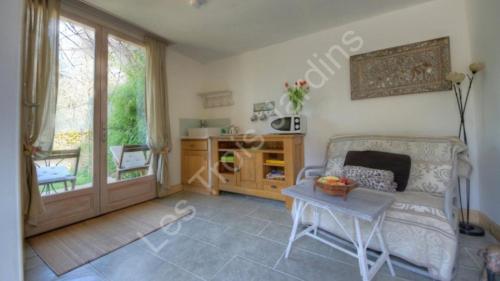 un salon avec un canapé et une table dans l'établissement Résidence Les Trois Jardins avec WIFI et Parking gratuit, à Sarlat-la-Canéda