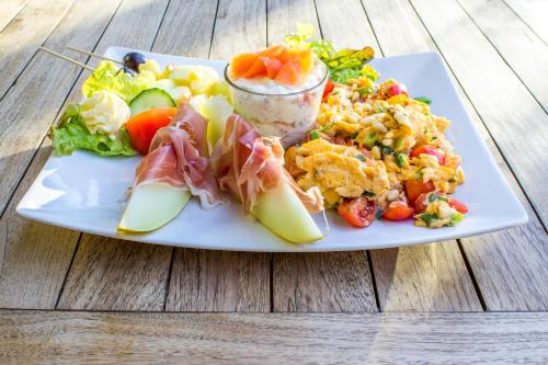 a plate of food with rice and salad on a wooden table at Landhaus Hotel Wolfratshausen in Wolfratshausen