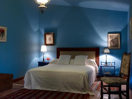 a blue bedroom with a bed and two chairs at Haciendas del Valle - Las Kentias in Valle de Guerra