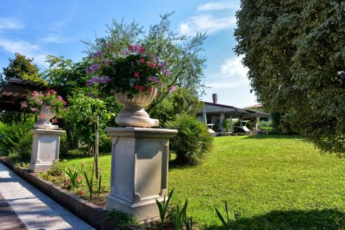 un vase de fleurs sur un pilier dans une cour dans l'établissement Casa Maria, à Manerba del Garda