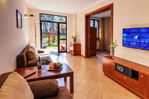 a living room with a couch and a tv at Columbus Rowy in Rowy