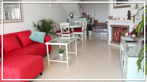 a living room with a red couch and a table at Casa Las Toro Playa in Chilches