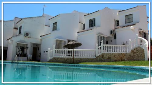una casa bianca con una piscina di fronte di Casa Las Toro Playa a Chilches