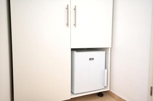a refrigerator in a kitchen with white cabinets at Villa Doris in Neum