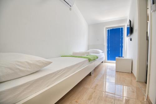 a white bedroom with a large bed and a window at Villa Doris in Neum