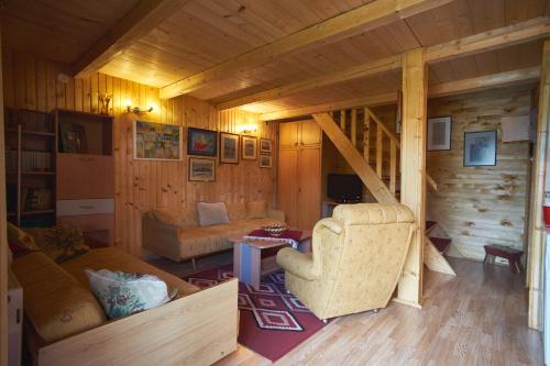 una sala de estar con sofá y una escalera en una cabaña en Cottage Walnut en Kolašin