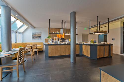 cocina y comedor con mesas y sillas en City Hotel, en Chemnitz