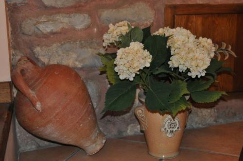 a vase with flowers in it next to a stone wall at Hotel la Casa del Abuelo in Albarracín