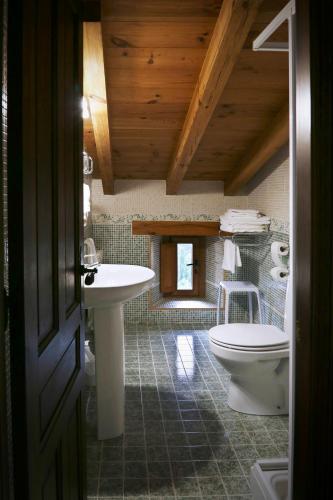 a bathroom with a toilet and a sink at Hotel Rural La Puebla in Orbaneja del Castillo