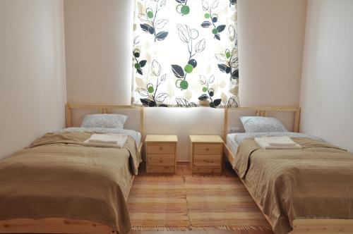 two twin beds in a room with a window at Bokros Vendégház in Tordas