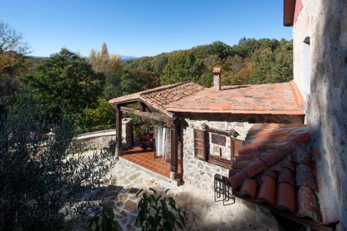 une maison en pierre avec un toit et une terrasse couverte dans l'établissement Posada Real Ruralmusical, à Puerto de Béjar