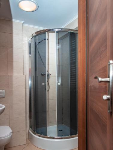 a shower with a glass door in a bathroom at Prima in Puławy