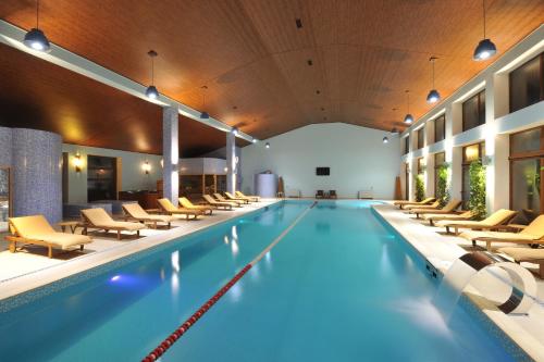 una piscina cubierta con tumbonas y una piscina en El Resort Hotel, en Qax