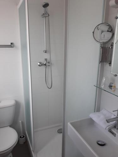 Un baño con ducha, inodoro y lavabo. en Hotel Eden, en Saint-Malo