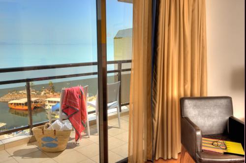 a room with a balcony with a view of the ocean at Leonardo Plaza Hotel Tiberias in Tiberias