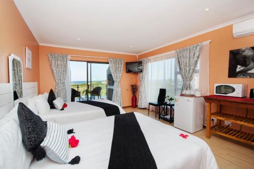 a hotel room with two beds and a piano at King Guest Lodge in Port Elizabeth