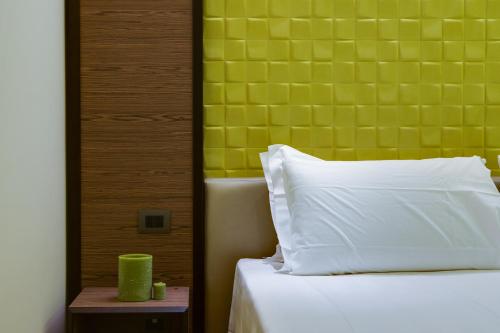 a bed with a white pillow and a green wall at Solo Experience Hotel in Florence