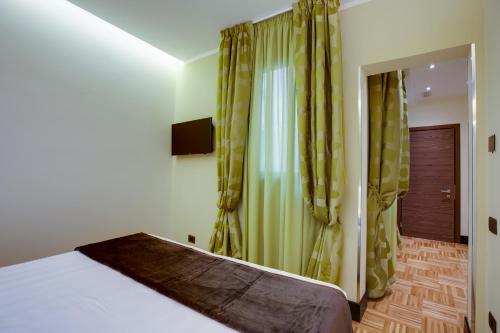 a bedroom with a bed and green curtains at Solo Experience Hotel in Florence