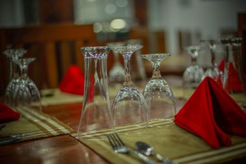 a table with wine glasses on a table with red napkin at Hotel City Grand Ella in Ella