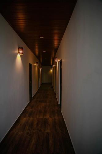 a hallway with a long corridor with doors and wood floors at Hotel City Grand Ella in Ella