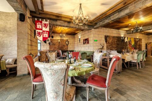 a dining room with tables and chairs and a chandelier at Royal Valentina Castle in Ognyanovo