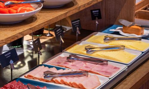 two trays of different types of meats and cheese at Thon Hotel Gyldenløve in Oslo