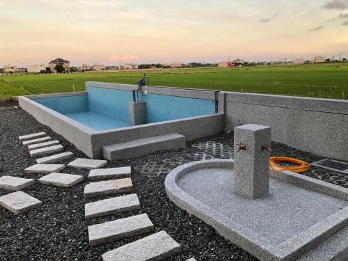 a swimming pool with a hose in a yard at 河沿悅舍ZW朋友同學聚會推薦l獎勵旅遊宜蘭包棟l家庭親子民宿l烤肉麻將浴缸戲水池 in Zhuangwei