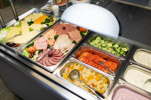 a buffet filled with different types of food in trays at Jugendhaus Klipper Norderney in Norderney