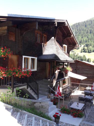 a log cabin with a porch and tables and chairs at Hotel-Restaurant Drei Tannen in Niederwald