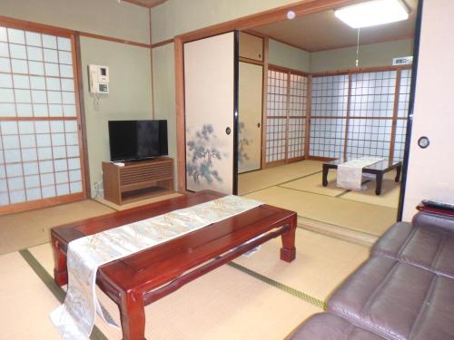 a living room with a couch and a tv at 光の宿 in Anan
