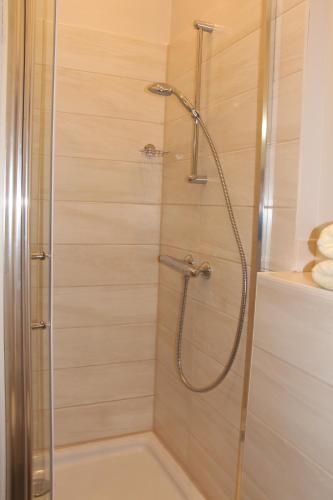 a shower with a glass door in a bathroom at Stars Berlin Apartments Essener Straße in Berlin