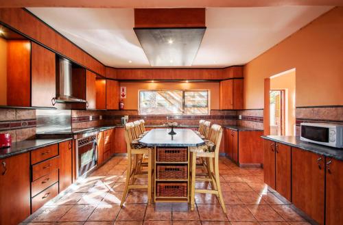 a kitchen with wooden cabinets and a table and chairs at King Guest Lodge in Port Elizabeth