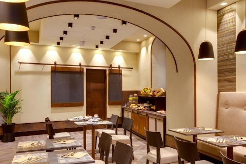 a restaurant with tables and chairs and a counter at Solo Experience Hotel in Florence