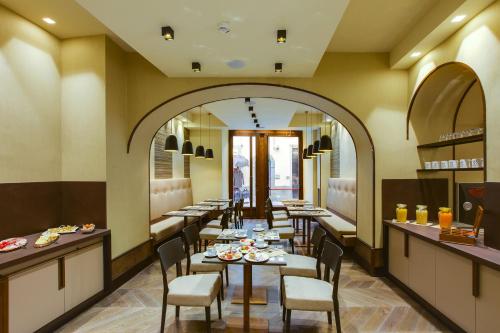 a restaurant with tables and chairs and a large mirror at Solo Experience Hotel in Florence