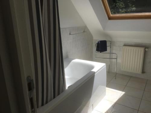 uma casa de banho com uma banheira e uma cortina de chuveiro em Gites de kermoel, Ouessant em Kernascléden