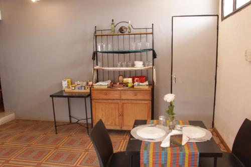 a dining room with a table and a table and a shelf at Ouaka in Ouagadougou