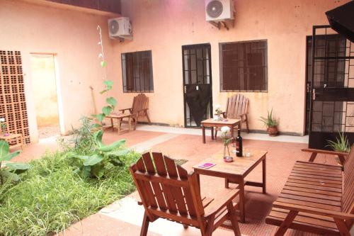 a patio with wooden chairs and a table and chairs at Ouaka in Ouagadougou