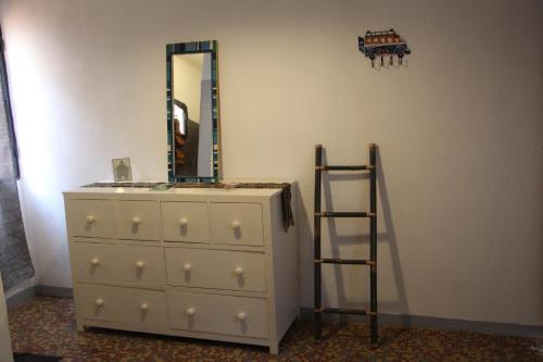 a dresser with a mirror and a ladder in a room at Ouaka in Ouagadougou