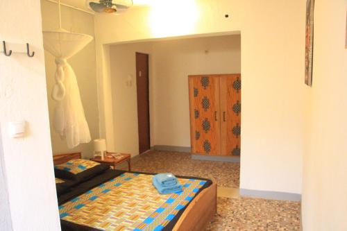 a bedroom with a bed and a door in it at Ouaka in Ouagadougou