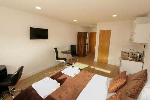 a living room with a bed and a kitchen at Trafalgar House in Stoke on Trent