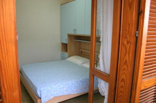 ein kleines Schlafzimmer mit einem Bett und einem Etagenbett in der Unterkunft L'arcobaleno in Valledoria